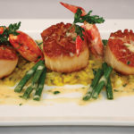 Pan-Seared Day-Boat Diver Scallops with lobster meunière sauce, haricots verts, and Romano cheese risotto