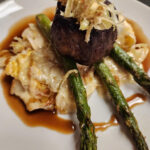 grilled beef tenderloin with scalloped potatoes, grilled asparagus, red wine demi glace and crispy leeks