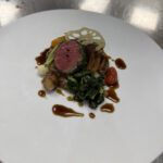 Seared Australian Wagyu Ribeye with porcini risotto, balsamic glazed pearl onions, baby heirloom tomato confit, sauteed Swiss chard, baby turnip, roasted brown straw mushrooms, crispy lotus root chip, roasted garlic and blue cheese butter, and rosemary veal jus