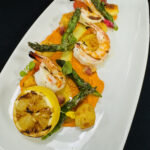 Key West Pink Shrimp and Asiago Gnocchi with Romesco, Confit Tomatoes, Charred Asparagus, Crispy Pancetta, Basil Oil, and Grilled Lemon